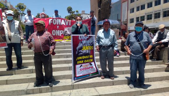 Pensionistas se encadenaron bajo el Arco Parabólico de Tacna para exigir mejores pensiones. (Foto: Adrian Apaza)