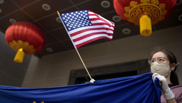 Un manifestante sostiene una bandera estadounidense fuera del consulado chino en Houston el 24 de julio de 2020, luego de que el Departamento de Estado de los Estados Unidos ordenara a China cerrar el consulado. (AFP/Mark Felix).