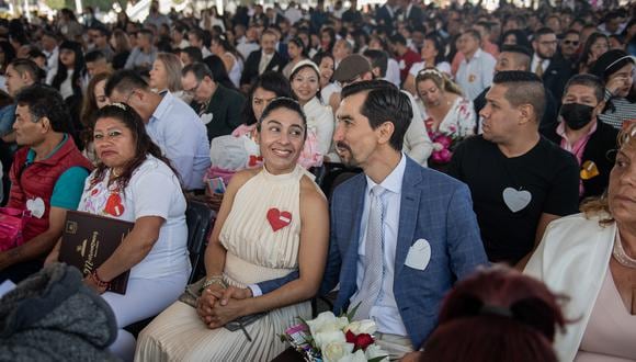 Una pareja se toma de la mano durante una celebración de boda colectiva el día de San Valentín en la explanada del Palacio Municipal de Nezahualcóyotl en Nezahualcóyotl, México, el 14 de febrero de 2023. (Foto de NICOLAS ASFOURI / AFP)