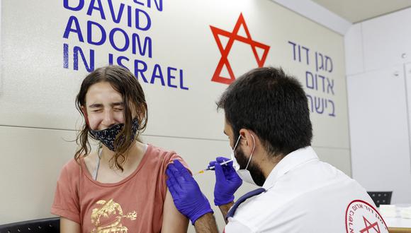 Una menor israelí recibe una dosis de la vacuna Pfizer / BioNTech contra el coronavirus Covid-19 durante una campaña del municipio de Tel Aviv-Yafo para fomentar la vacunación de adolescentes en Israel. (Foto de JACK GUEZ / AFP).