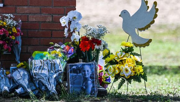 La foto de una niña pequeña, víctima del tiroteo, se ve junto a las flores colocadas en un monumento improvisado frente a la Escuela Primaria Robb en Uvalde, Texas, el 25 de mayo de 2022. - La comunidad latina unida de Uvalde estaba destrozada con duelo el miércoles después de que un adolescente con chaleco antibalas entró en la escuela y mató a 19 niños y dos maestros, en el último espasmo de violencia armada mortal en los EE. UU. (Foto de CHANDAN KHANNA / AFP)