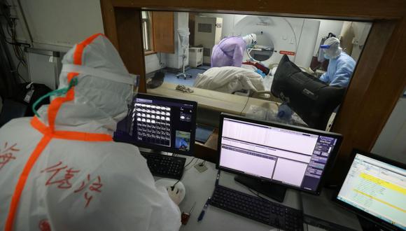 Esta foto tomada el 28 de febrero de 2020 muestra a un miembro del personal médico mirando una pantalla mientras un paciente infectado por el coronavirus COVID-19 realiza una tomografía computarizada en el hospital de la Cruz Roja en Wuhan, en la provincia central china de Hubei. (AFP).
