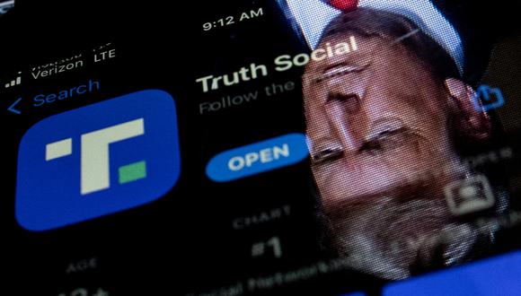 En esta ilustración fotográfica de archivo tomada el 21 de febrero de 2022, una imagen del expresidente Donald Trump reflejada en la pantalla de un teléfono que muestra la aplicación Truth Social, en Washington, DC. (Foto de Stefani Reynolds / AFP)