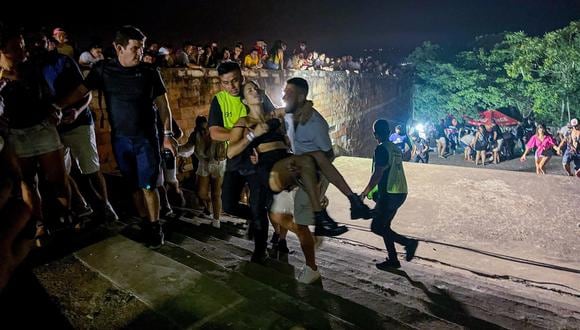 Unos hombres cargan a una mujer afectada tras un tiroteo registrado en un evento musical en San Bernardino (Paraguay). (Foto:  EFE/ Stringer)