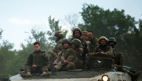 Soldados ucranianos viajan en un vehículo blindado de transporte de personal (APC) en una carretera de la región oriental de Lugansk el 23 de junio de 2022, en medio de la invasión militar de Rusia lanzada contra Ucrania. (Foto de Anatolii Stepanov / AFP)