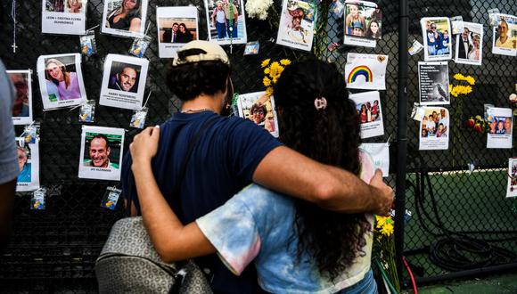 La gente visita el memorial improvisado para las víctimas del derrumbe del edificio en Surfside, Florida, al norte de Miami Beach. (Foto: CHANDAN KHANNA / AFP).