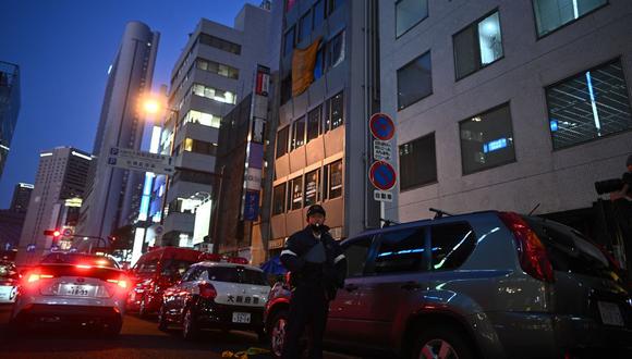 Un oficial de policía se para frente a un edificio de oficinas donde se produjo un incendio en Osaka el 17 de diciembre de 2021. (Foto de Philip FONG / AFP)