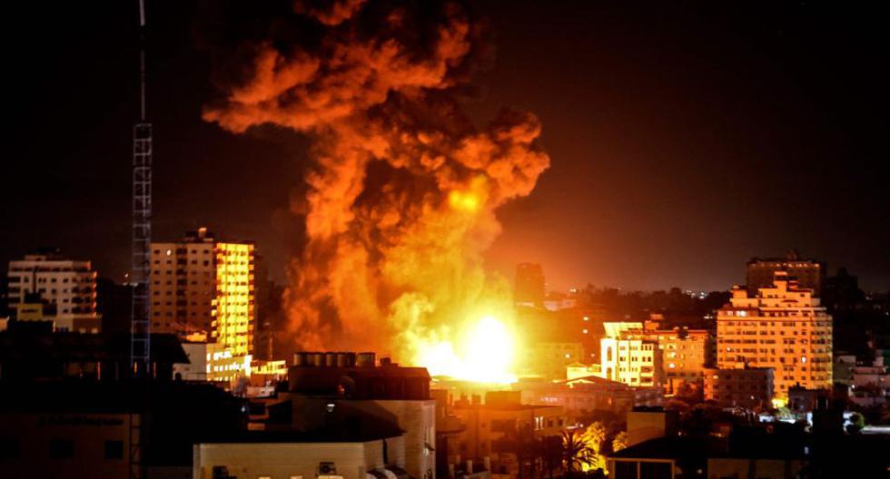 El fuego y el humo se elevan por encima de los edificios en la ciudad de Gaza mientras aviones de combate israelíes apuntan al enclave palestino, a principios del 17 de mayo de 2021.  (AFP / MAHMUD HAMS).