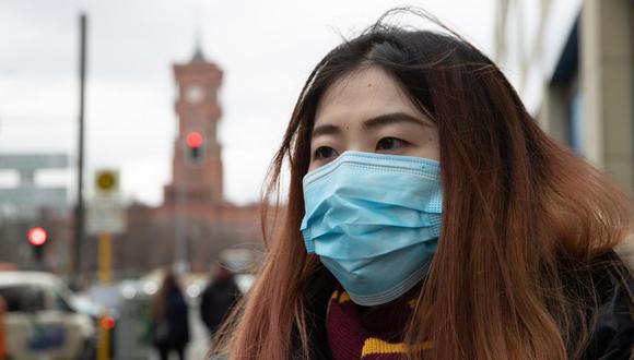 Un turista de China usa una mascarilla médica mientras hace turismo en Berlín, Alemania, el 28 de febrero de 2020. (EFE).