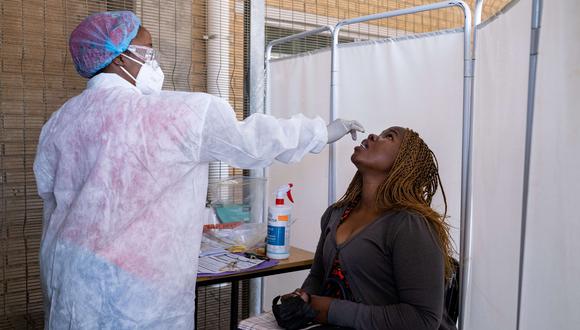 Una mujer recibe un hisopo nasal, de un trabajador de la salud que usa equipo de protección personal (EPP), para ser examinado por COVID-19 en el Fourways Life Hospital en Johannesburgo el 28 de junio de 2021. (Foto: Emmanuel Croset / AFP)