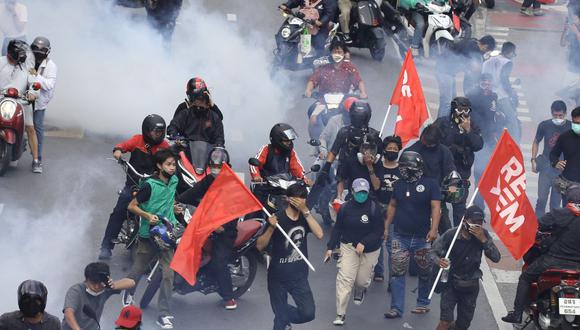 Manifestantes antigubernamentales reaccionan cuando la policía dispara gases lacrimógenos durante una marcha en la carretera hacia la casa del primer ministro en Bangkok, Tailandia, el 7 de agosto de 2021. (EFE/EPA/NARONG SANGNAK).