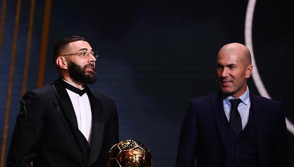 Real Madrid's French forward Karim Benzema receives the Ballon d'Or award from French former forward football player Zinedine Zidane during the 2022 Ballon d'Or France Football award ceremony at the Theatre du Chatelet in Paris on October 17, 2022. (Photo by FRANCK FIFE / AFP)
