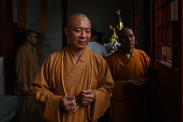 Esta fotografía tomada el 26 de mayo de 2021 muestra al monje budista Zhi Xiang en un templo en Shanghái. (Hector RETAMAL / AFP).