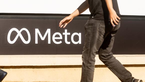 Una persona pasa frente a un logotipo recientemente presentado para "Meta", la empresa matriz de Facebook, frente a la sede de Facebook en Menlo Park, California.  (Foto de NOAH BERGER / AFP)