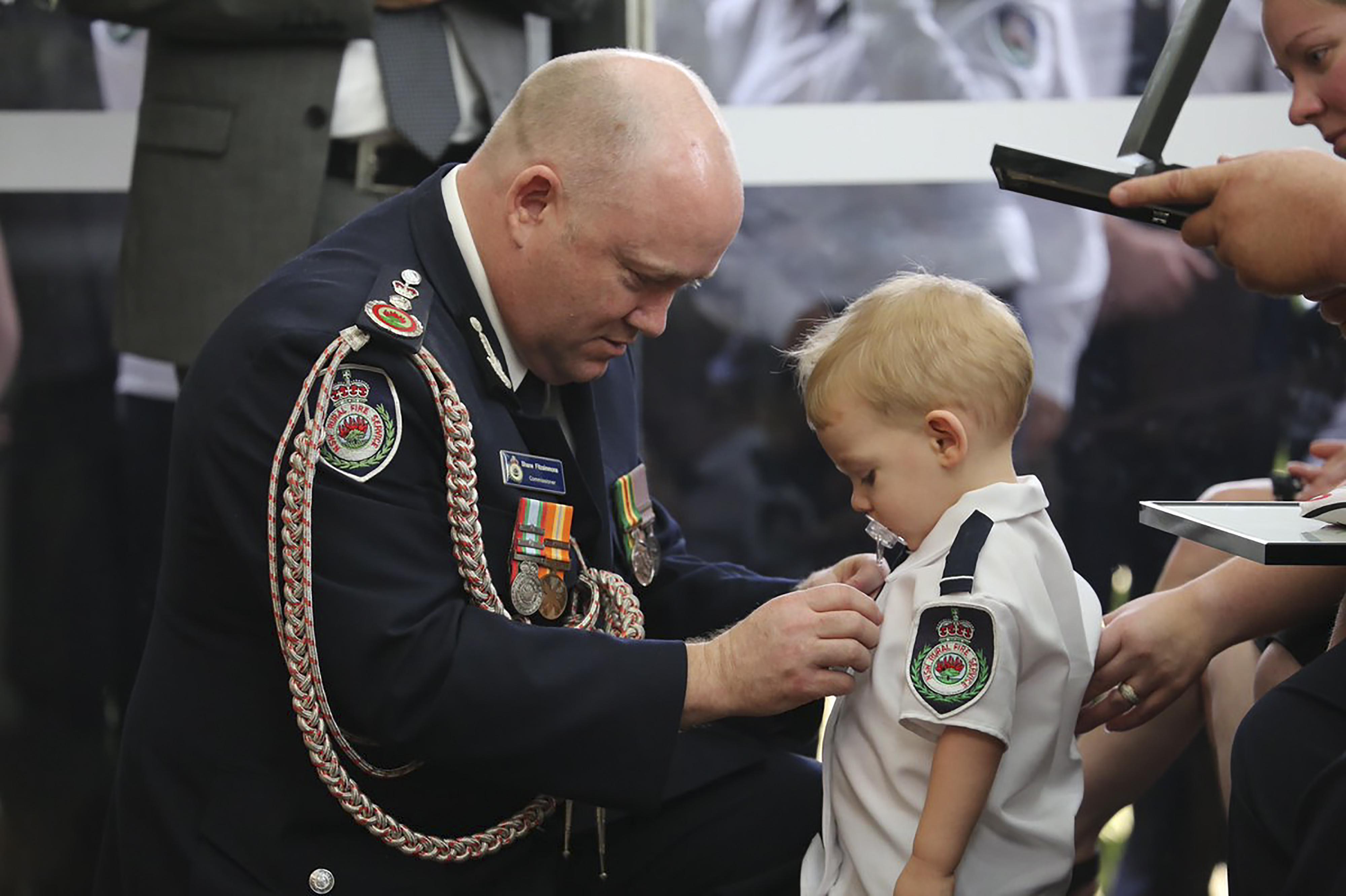 Niño recibe medalla en honor a su padre, quien murió apagando los incendios en Australia. Foto: AFP