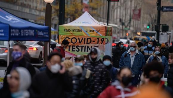 La gente pasa frente a un puesto de prueba de COVID-19 en una calle de la ciudad de Nueva York el 21 de diciembre de 2021. (Foto: Ed JONES / AFP)