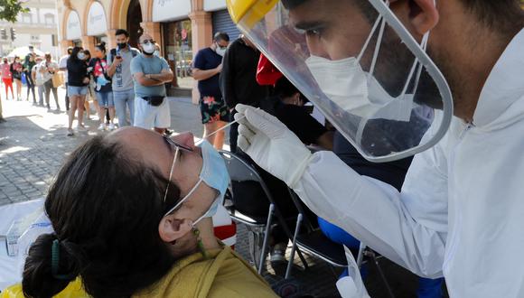 Un trabajador de la salud toma una muestra nasal de una mujer para una prueba de PCR para la enfermedad del nuevo coronavirus COVID-19 que se ofrece de forma gratuita en las calles de Santiago. (Foto: Javier TORRES / AFP)