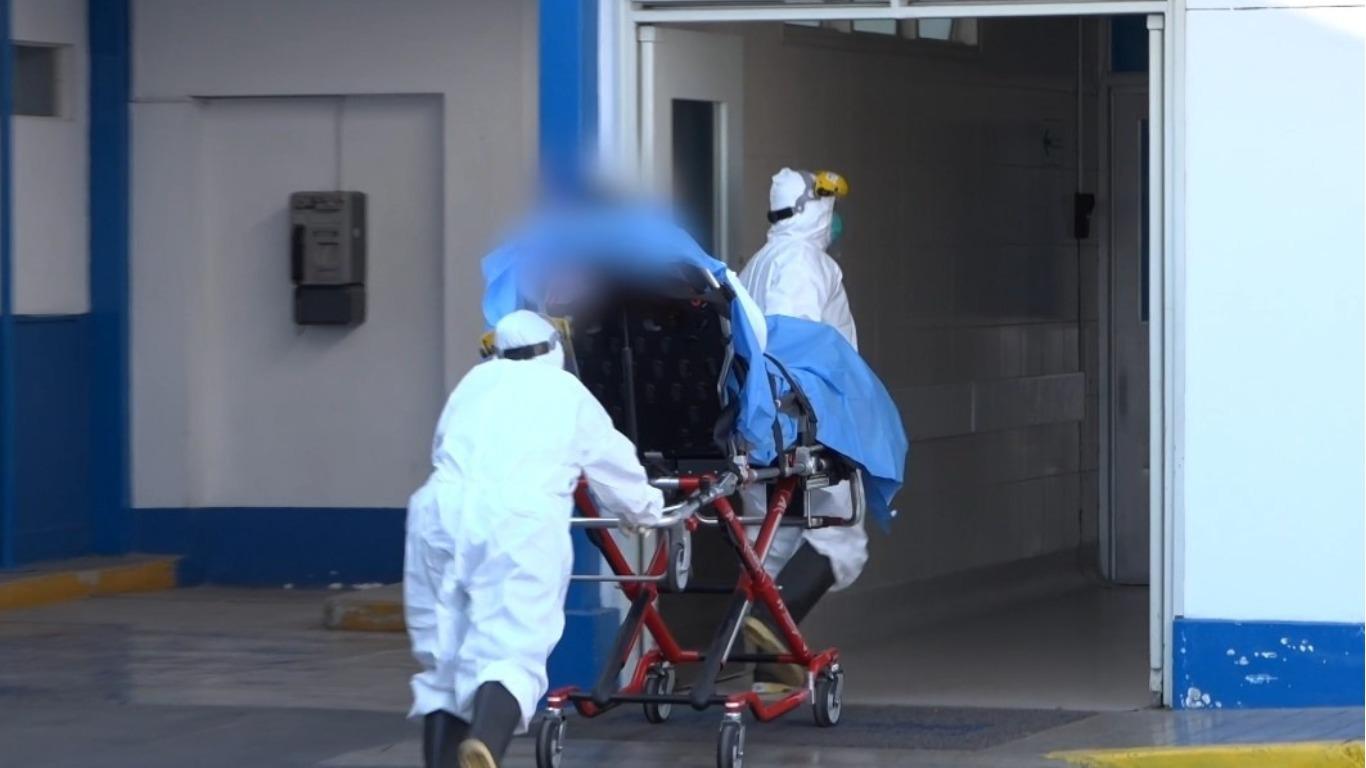 El paciente con coronavirus siendo trasladado en una camilla hacia el área de emergencia.