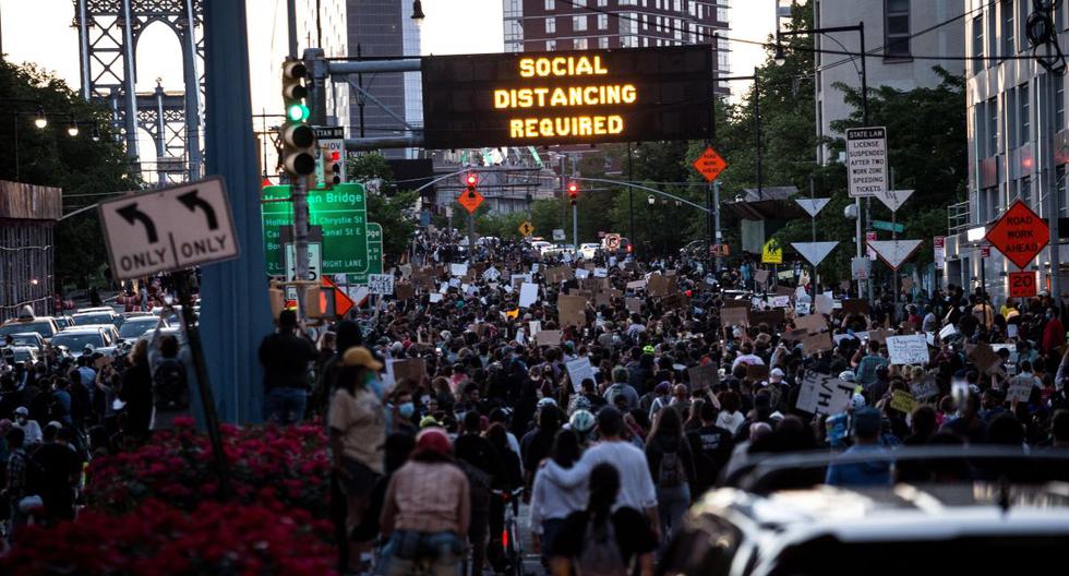 Imagen referencial. Manifestantes son vistos marchando de Brooklyn a Manhattan en Nueva York. Letrero recomienda los ciudadanos mantener una distancia para evitar contagios por coronavirus. (EFE/ALBA VIGARAY).