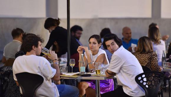 En esta imagen se puede observar a un grupo de jóvenes bebiendo al aire libre, todos sin mascarilla. (EFE/EPA/Alessandro Di Marco)