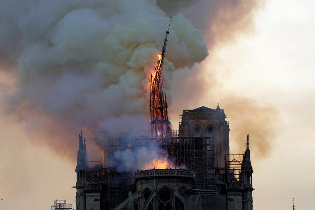El campanario y la aguja de la emblemática Catedral de Notre-Dame se derrumban cuando la catedral se ve envuelta en llamas en el centro de París el 15 de abril de 2019. - Un gran incendio arrasó el techo de la famosa Catedral de Notre-Dame en el centro de París el 15 de abril 2019, enviando llamas y enormes nubes de humo gris al cielo. Las llamas y el humo salieron de la aguja y el techo de la catedral gótica, visitada por millones de personas al año. Un portavoz de la catedral le dijo a AFP que la estructura de madera que sostenía el techo estaba siendo destruida por el incendio. (Foto por Geoffroy VAN DER HASSELT / AFP)