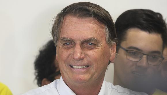 El presidente de Brasil y candidato a la reelección, Jair Bolsonaro, sonríe durante una conferencia de prensa ofrecida al aterrizar en el aeropuerto internacional de Fortaleza, Estado de Ceará, Brasil, el 15 de octubre de 2022. (Foto de JL ROSA / AFP)