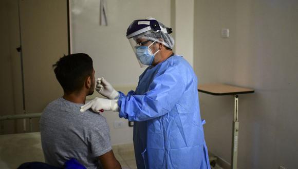 Imagen referencial. Un doctor toma una muestra de un hisopo de un hombre para realizar la prueba de COVID-19 en el Hospital Público Doctor Alberto Antranik Eurnekian de Ezeiza, en las afueras de Buenos Aires el 1 de julio de 2020. (RONALDO SCHEMIDT / AFP).