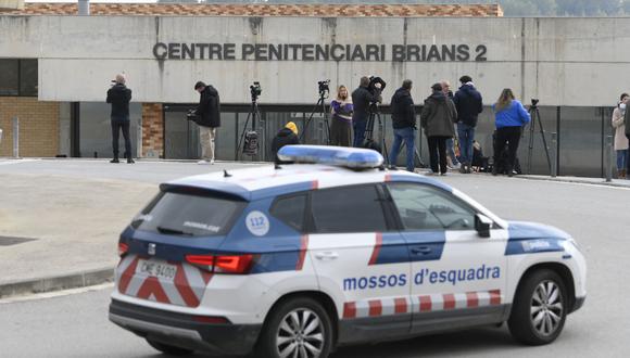 Un coche de policía se ve junto a los periodistas que informan fuera de la prisión de San Esteve Sesrovires, a 40 km de Barcelona. (Foto de Josep LAGO / AFP)