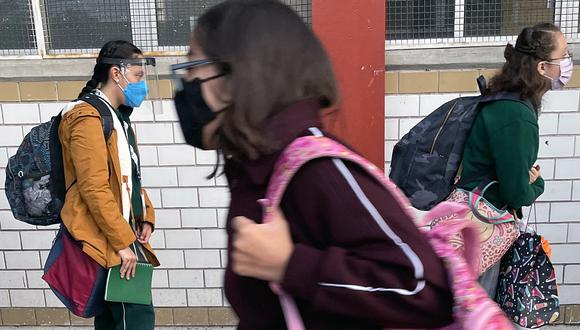 Adolescentes con cubrebocas llegan a la escuela en la Ciudad de México el 10 de enero de 2022.  (Foto por ALFREDO ESTRELLA / AFP)