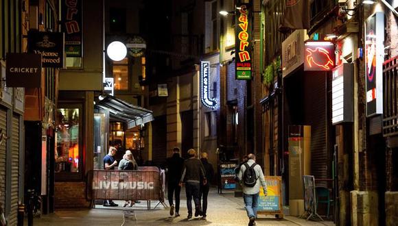 Varias personas caminan por una calle de bares de Liverpool, Inglaterra, en pleno auge de contagios de coronavirus. (EFE/EPA/PETER POWELL).