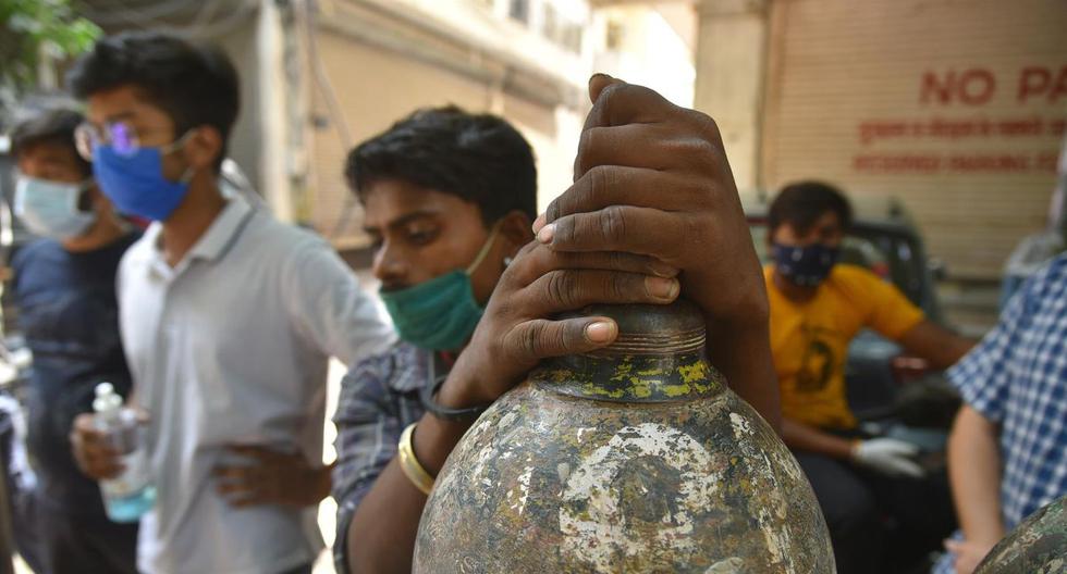Los indios esperan para llenar sus cilindros de oxígeno en un proveedor de oxígeno en Nueva Delhi. (EFE / EPA / IDREES MOHAMMED).