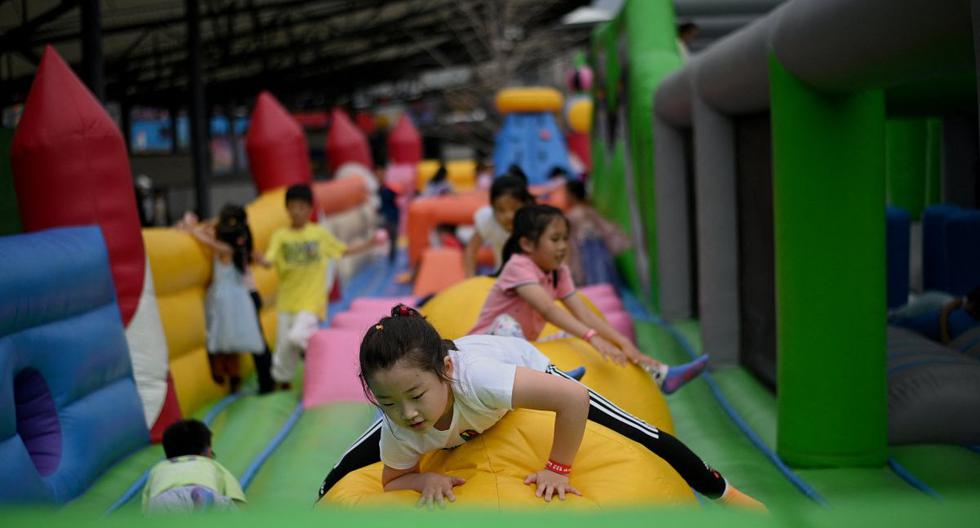 Los niños juegan en un "castillo hinchable" instalado en un centro comercial en el Día Internacional del Niño en Beijing el 1 de junio de 2021. (Noel Celis / AFP).