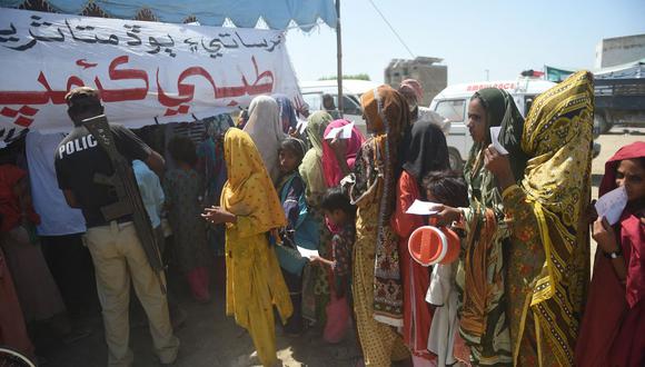 Los residentes locales desplazados por las inundaciones se reúnen en un campamento médico improvisado ubicado en el distrito de Dadu, provincia de Sindh, el 27 de septiembre de 2022. (Foto de Rizwan TABASSUM / AFP)