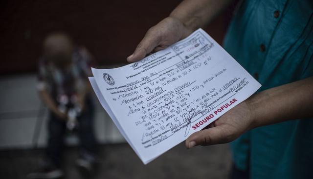 La madre, Esperanza Pax, muestra las recetas para el cáncer del niño mexicano Hermes Soto para el cáncer. (AFP).