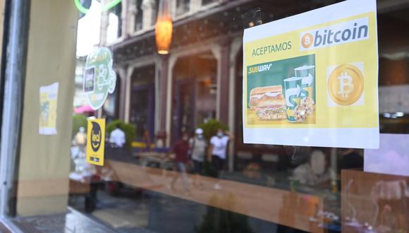Una señal que dice "Aquí aceptamos bitcoin" se ve afuera de un restaurante en San Salvador, el 18 de noviembre de 2021. (Foto de Sthanly ESTRADA / AFP)