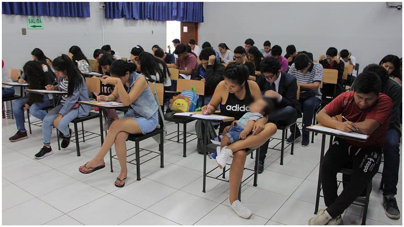 Joven madre da examen de admisión junto a su bebé