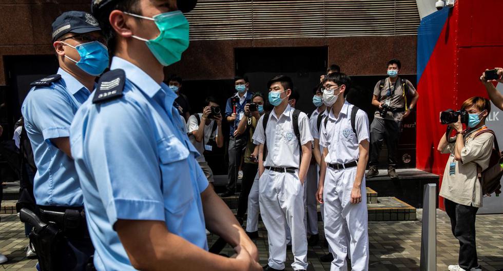 Imagen referencial. Policías y estudiantes son vistos en una escuela en Hong Kong, el 12 de junio de 2020. (ISAAC LAWRENCE / AFP).