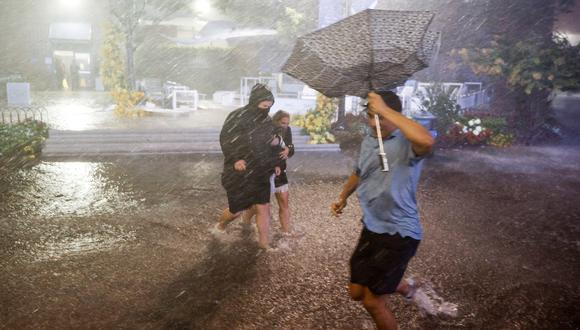 Personas "navegan" por fuertes lluvias y pasillos inundados en el Centro Nacional de Tenis Billie Jean King por los remanentes del huracán Ida. (Foto:  EFE/EPA/JUSTIN LANE)