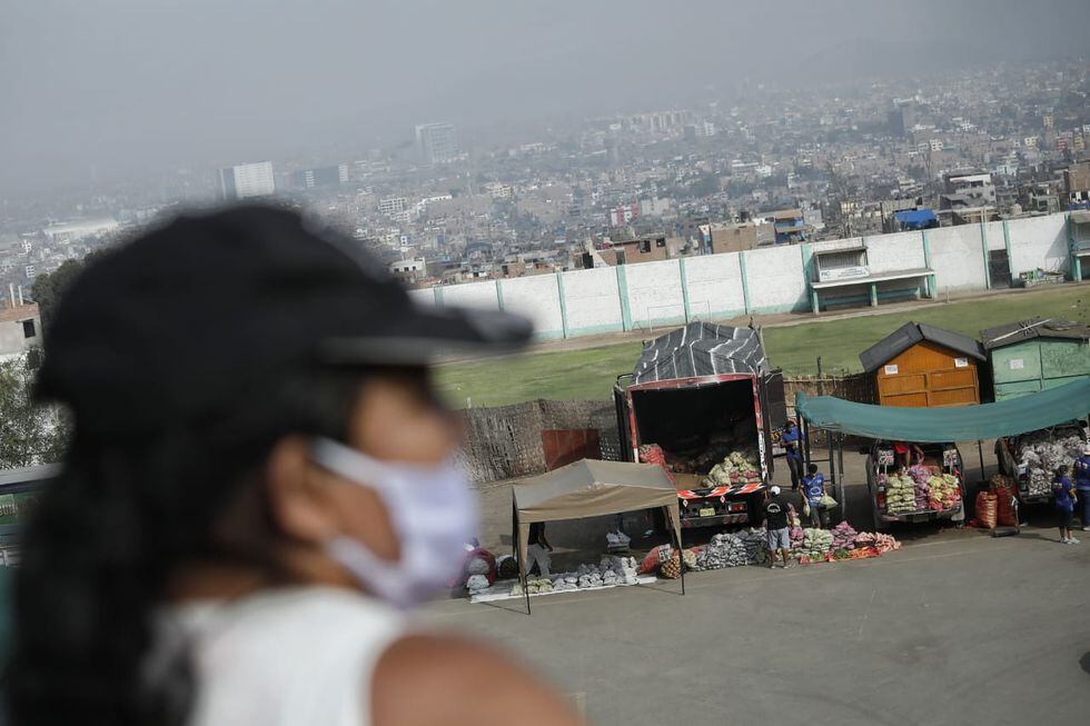 Mujeres usan mascarillas mientras esperan ingresar a mercado en el día 20 de la cuarentena. (Foto: Miguel Yovera/GEC)