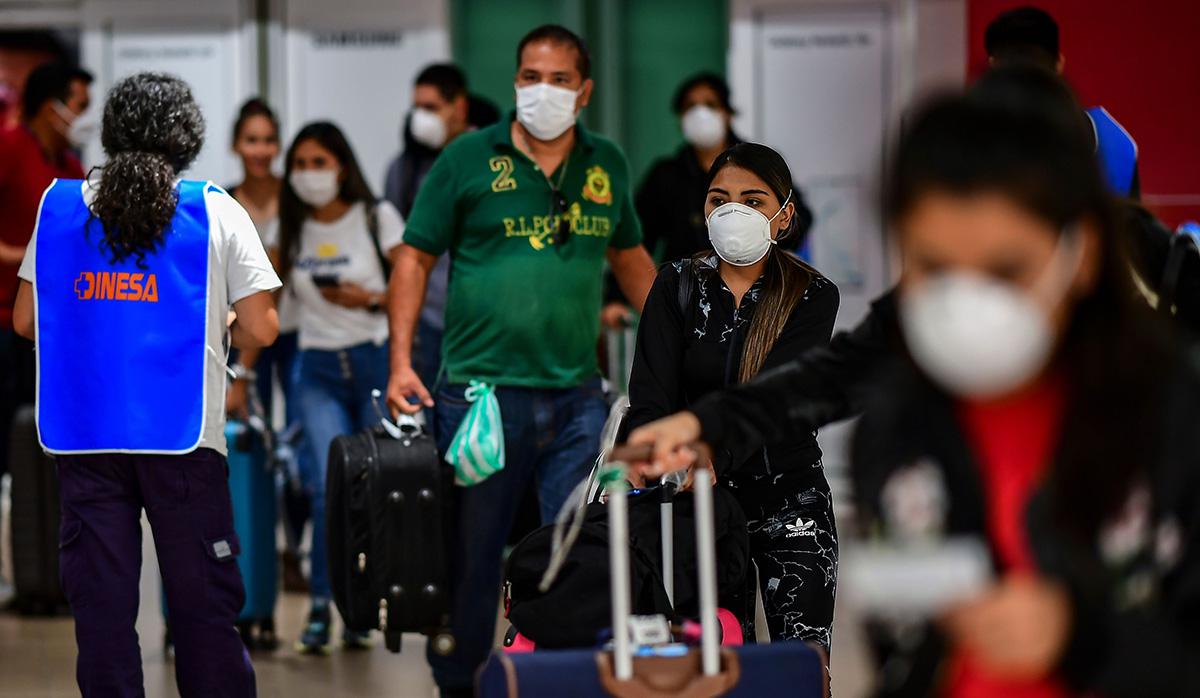 Los pasajeros usan mascarillas como medida preventiva contra la propagación del coronavirus COVID-19 en un aeropuerto. (Foto: Referencial - AFP)