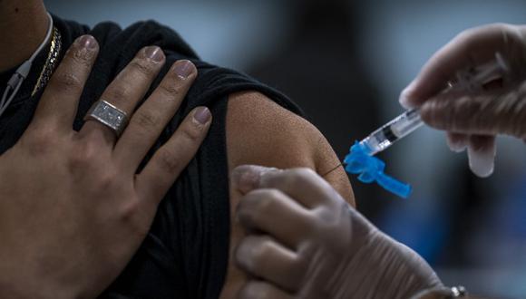 Un trabajador de la salud vacuna a una persona contra el coronavirus. (Foto: Ricardo Arduengo / AFP)