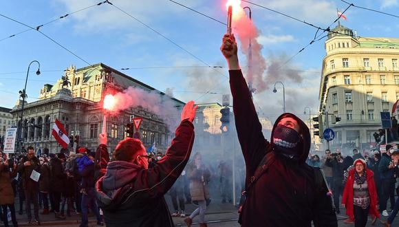 Los manifestantes encienden bengalas durante un mitin organizado por el Partido de la Libertad de extrema derecha de Austria, FPOe, contra las medidas tomadas para frenar la pandemia del coronavirus (Covid-19), en la plaza Maria Theresien Platz en Viena, Austria, el 20 de noviembre de 2021. (Foto: Joe Klamar / AFP)