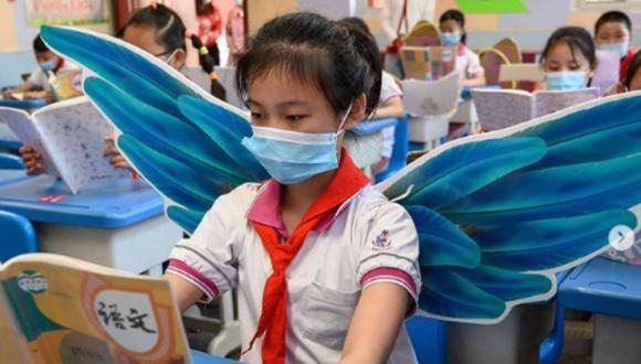 China: niños usan alas de tela en las escuelas para mantener su distancia social. Fotos: BBC