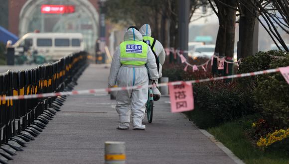 Esta foto tomada el 22 de diciembre de 2021 muestra a los guardias de seguridad caminando en un área que está bajo restricciones luego de un reciente brote de coronavirus en Xi'an, en la provincia norteña de Shaanxi, en China. (Foto de AFP)