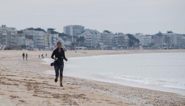 Una mujer trota en la playa de La Baule, en el oeste de Francia, el 13 de mayo de 2020. (AFP / Loic VENANCE).