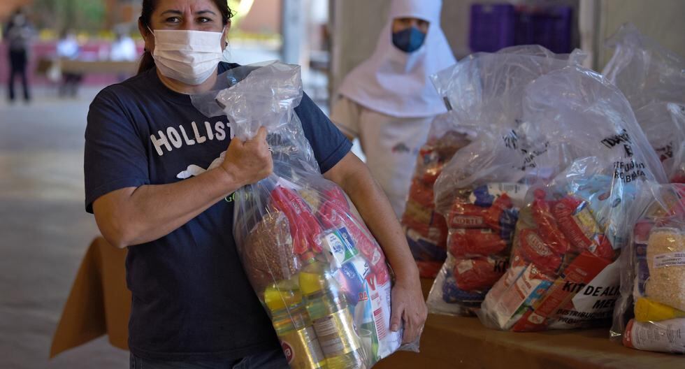 Una mujer lleva una bolsa con alimentos entregados como parte de un plan de ayuda del gobierno en Asunción (Paraguay), el 5 de abril de 2020, durante un bloqueo total contra la propagación del nuevo coronavirus. (Norberto DUARTE / AFP).