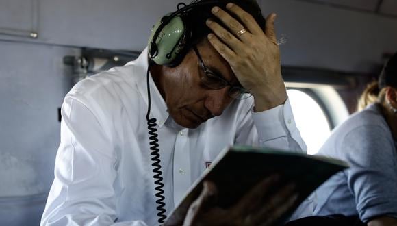 Martín Vizcarra viajando en un helicóptero mientras mira un cuaderno. | Foto: Presidencia.