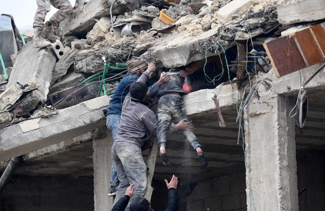 Los residentes recuperan a una niña herida de los escombros de un edificio derrumbado luego de un terremoto en la ciudad de Jandaris, en el campo de la ciudad de Afrin, en el noroeste de Siria, en la parte rebelde de la provincia de Alepo, el 6 de febrero de 2023.  (Foto de Rami al SAYED / AFP)