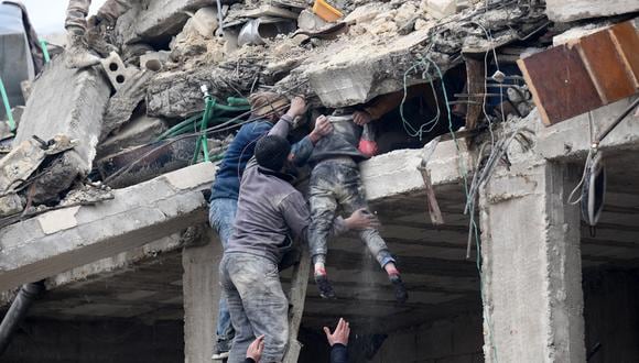 Los residentes recuperan a una niña herida de los escombros de un edificio derrumbado luego de un terremoto en la ciudad de Jandaris, en el campo de la ciudad de Afrin, en el noroeste de Siria, en la parte rebelde de la provincia de Alepo, el 6 de febrero de 2023. (Foto de Rami al SAYED / AFP)