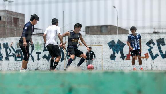 Jóvenes juegan fútbol pese a estar prohibido, en las lozas deportivas en la zona de Barboncito, San Martín de Porres. Foto: Miguel Yovera / @photo.gec